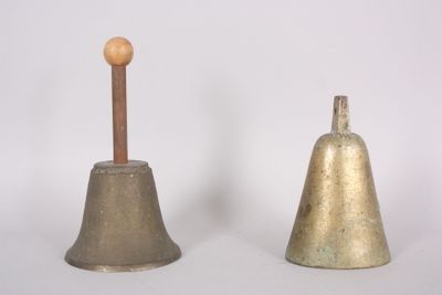 pair of antique brass bells with wooden handle on white background