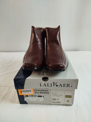 des chaussures en cuir marron posées sur une boîte, sur une surface blanche