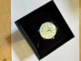 une boîte noire contenant une montre blanche
