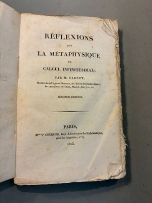 un vieux livre posé sur une table à côté d'un autre livre