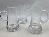 three glass mugs sitting next to each other on a table