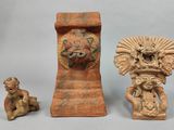 trois figurines anciennes posées les unes à côté des autres sur une table