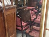 un miroir accroché au mur dans une pièce où se trouvent des chaises et une table