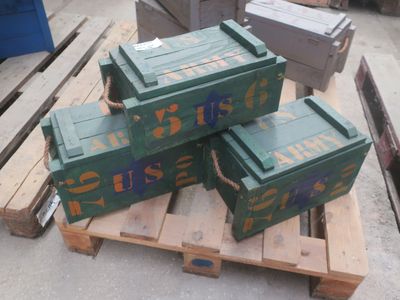 trois cartons verts posés sur une palette, elle-même posée sur une autre palette