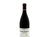 the bottle of red wine is sitting on a white surface