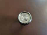 a close up picture of a small clock on a table