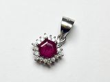 un gros plan d'un pendentif en rubis et diamants sur fond blanc