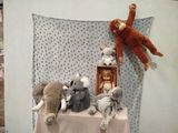 several stuffed animals are sitting on a table with a blanket
