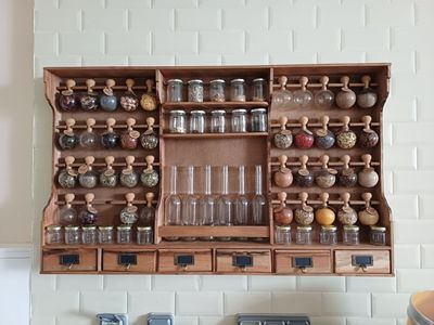 une armoire en bois sur laquelle sont posées de nombreuses bouteilles et bocaux