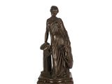 statue en bronze représentant une femme accompagnée d'un chien, posée sur un socle