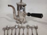 une théière en argent avec des cuillères à côté