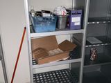 une étagère métallique sur laquelle sont posées des boîtes, dans une pièce