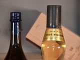 two bottles of wine sitting on a table next to each other