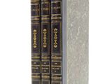 three books are stacked on top of each other on a white surface