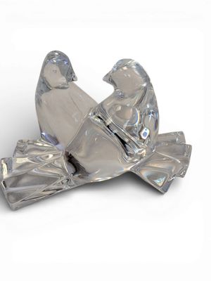 une figurine en verre représentant un homme et une femme assis sur un banc