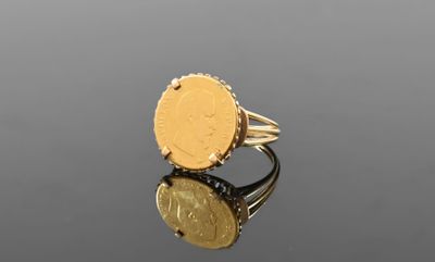 a close up of a gold ring with a coin on it