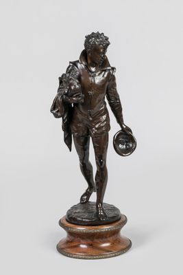 statue en bronze représentant un homme tenant une balle, posée sur un socle en bois