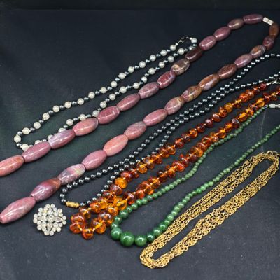 plusieurs perles et chaînes de différentes couleurs sur un fond noir