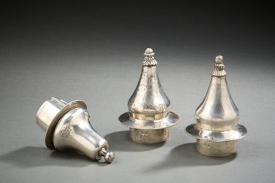 trois pièces d'argent sont posées sur une surface grise