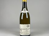 une bouteille de vin blanc posée sur une table blanche