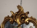 a mirror with a gold frame hanging on a wall