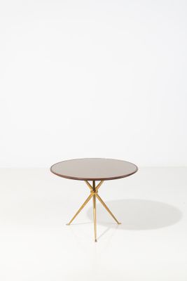 une table basse ronde avec des pieds dorés et un plateau blanc