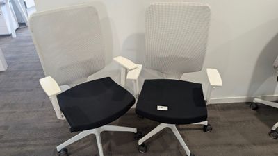 deux chaises de bureau avec des assises noires et blanches dans une pièce