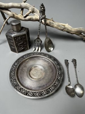un plateau en argent avec des cuillères et un repose-cuillères posé sur une table