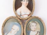 trois portraits miniatures représentant une femme, un homme et un enfant, dans un cadre doré