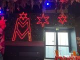 brightly lit neon signs hang from the ceiling of a restaurant