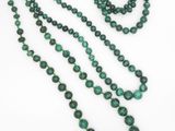 un gros plan sur un collier de perles vertes et une paire de boucles d'oreilles