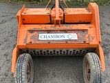 an orange lawn mower sitting on top of a dirt field
