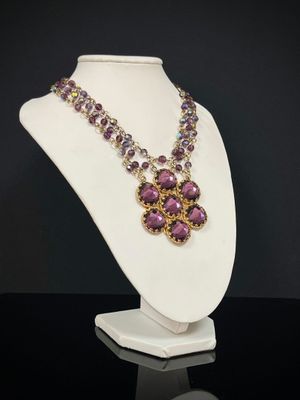 un mannequin blanc orné de perles violettes et d'un collier