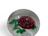 a glass bowl with a rose on it on a white surface