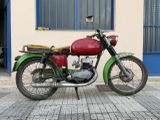 a red and green motorcycle parked in front of a building