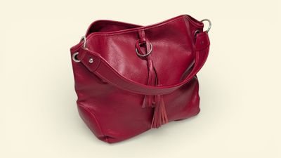 red leather handbag with tassels on a white background