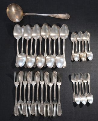 un grand nombre de cuillères et de fourchettes en argent disposées sur une table