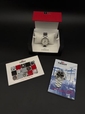 deux montres dans leur écrin et des livrets posés sur un fond noir