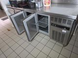 un plan de travail en inox équipé de deux réfrigérateurs et d'un congélateur