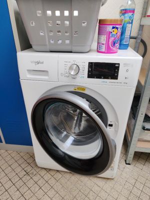 une machine à laver surmontée d'un panier