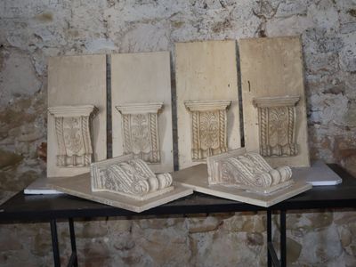 trois œuvres d'art posées sur une table devant un mur de briques