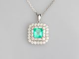 an emerald and diamond pendant on a silver chain