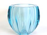 a blue glass vase sitting on a white surface