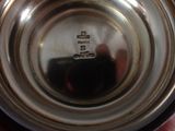 someone is holding a silver cup with a small amount of liquid in it