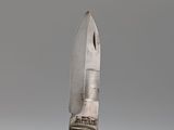 a small knife with a wooden handle on top of a brush