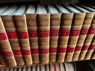 Plusieurs vieux livres sont empilés sur une étagère dans une bibliothèque