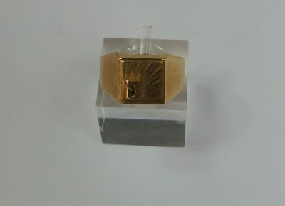 a gold ring with a diamond in it on a white surface