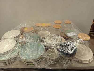 de nombreuses assiettes et bols emballés dans du plastique, posés sur une table