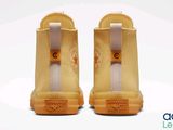 the back view of a pair of yellow sneakers with white soles