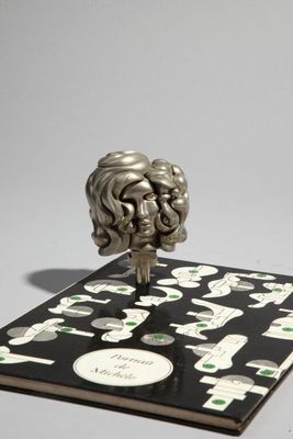 une image représentant un livre sur lequel est posée une statue en argent
